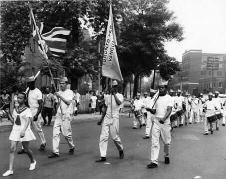 Black and white photo band members in the Emancipation Day Parade. Photo noir et blanc de membres d'une orchestre marchant dans la parade d'émanicpation