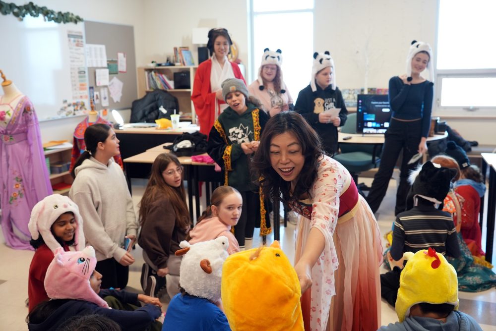Woman engaging with children in a classroom. - Une femme discute avec des enfants dans une salle d'école